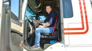 Ein Mann sitzt am Steuer eines Lastwagens. Ein Mann sitzt am Steuer eines Lastwagens.