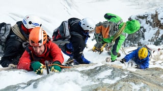Bergsteiger in Fels und Eis beim gefährlichen Abstieg.