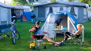 Paar grilliert vor dem eigenen Zelt