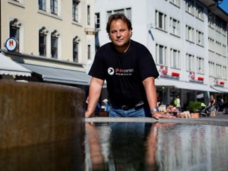 Ein Mann steht in der Winterthurer Altstadt. Im vordergrund ein Brunnen