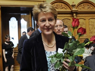 Simonetta Sommaruga mit einem Strauss roter Rosen auf dem Weg zum Rednerpult