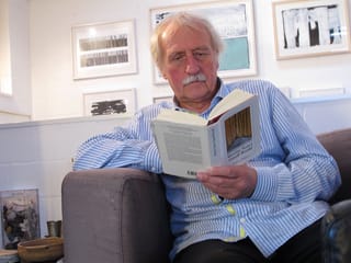 Ernst Wohlwend sitzt lesend in einem Sessel. Ernst Wohlwend sitzt lesend in einem Sessel.