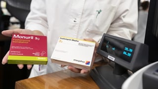 Apotheker präsentiert zwei Medikamente. Apotheker präsentiert zwei Medikamente.