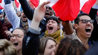 Eine gruppe junger Demonstranten schreit in die Menge.