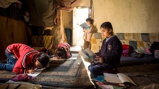 Kinder lernen in einem Raum in verschiendenen Bücher