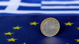 Ein-Euro-Münze auf den Flaggen der EU und Griechenlands