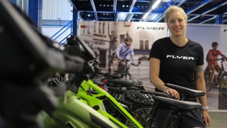 Eine Frau steht in einer Reihe mit Elektrovelos. Eine Frau steht in einer Reihe mit Elektrovelos.