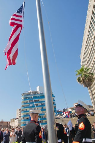 U.S. Marines in Galauniform hissen die US-Fahne vor der Botschaft.