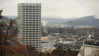 Sicht auf Winterthur mit rauchenden Kaminen, Links ein Hochhaus, rechts die zwei Türme der Stadtkirche.