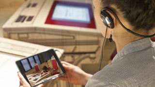 Eine Frau schaut sich einen Film auf einem i-Pad an,