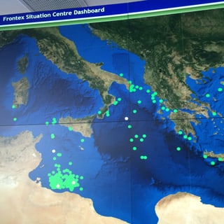 Grüne Punkte auf einer Landkarte symbolisieren die Flüchtenden nach Europa.