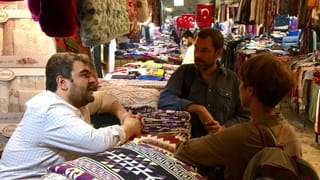 Person hinter einem Stand in einem Bazar Person hinter einem Stand in einem Bazar
