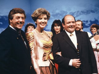 Zwei Männer und eine Frau während einer Fernsehsendung.