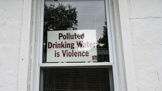 Protestschild gegen das verschmutzte Trinkwasser an einer Tür.