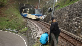 Kameramann und Assistent drehen am Rande der Bahngeleise den herannnahenden Zug. 