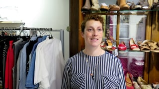 Eine Frau vor Kleiderstangen. Eine Frau vor Kleiderstangen.