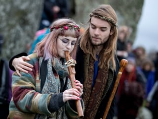  Junge Frau spielt Flöte, junger Mann hält Arm um sie