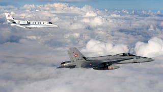 Ein F/A-18-Kampfjet begleitet den Bundesratsjet hoch über den Wolken. Ein F/A-18-Kampfjet begleitet den Bundesratsjet hoch über den Wolken.