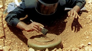 Ein Mitglied der UNO-Friedenstruppen bei der Entschärfung einer Landmine.