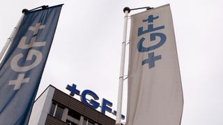 Ein Haus mit Georg-Fischer-Logo, davor Fahnen mit demselben Logo.