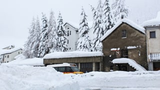 Verschneites Dorf mit einem Postauto