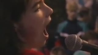 Eine junge Frau singt in ein Mikrophon hinein.