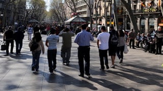 Zahlreiche Menschen spazieren dem Boulevard Las Ramblas entlang. Zahlreiche Menschen spazieren dem Boulevard Las Ramblas entlang.
