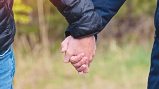 Zwei Männer halten Hände in Jacken. Zwei Männer halten Hände in Jacken.