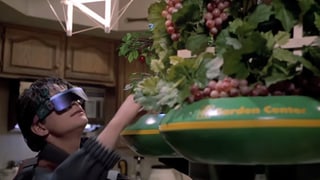 Junger Mann mit dunkler Brille nimmt eine Frucht aus einer futuristischen Früchteschale