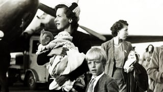 Frau mit Kindern auf Flugfeld