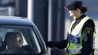 Eine schwedische Beamtin kontrolliert einen Einreisenden in Lernacken. 