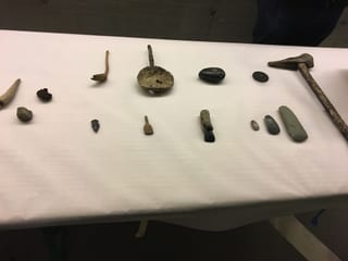 Werkzeuge aus der Pfahlbauzeit sind auf einem Tisch ausgestellt.