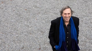 ein Mann mit schwarzem Mantel und blauem Schal ein Mann mit schwarzem Mantel und blauem Schal