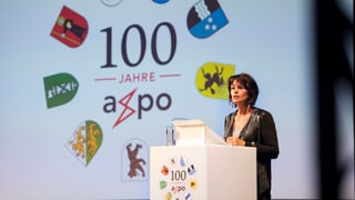 Bundesrätin Doris Leuthard referiert an der 100-Jahr-Feier des Unternehmens im August 2014. Am Rednerpult sind die Wappen der neum Kantone zus ehen, denen die Axpo gehört.n 