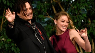 Johnny Depp und Amber Heard winken in die Kameras.