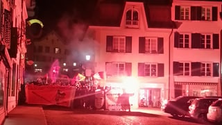 Demonstranten mit roten Fackeln in Stadt.