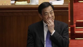 Bo Xilai im Gerichtssaal. Er hält sich die Hand vor den Mund. Bo Xilai im Gerichtssaal. Er hält sich die Hand vor den Mund.