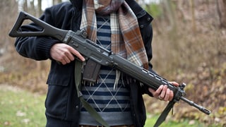 Mann hält Sturmgewehr Mann hält Sturmgewehr