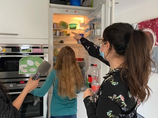 Annina und Ladina wählen Lebensmittel aus dem Kühlschrank aus. 