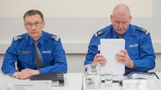 Zwei Polizisten anlässlich einer Medienkonferenz sitzen an einem Tisch. 