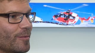 Hardegger im Seitenporträt. Im Hintergrund ein Foto eines Helikopters. Hardegger im Seitenporträt. Im Hintergrund ein Foto eines Helikopters.
