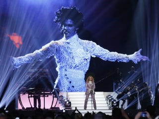 Madonna auf der Bühne vor einer grossen Projektion von Prince Madonna auf der Bühne vor einer grossen Projektion von Prince