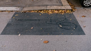 Ein übermaltes Velosymbol auf einer Strasse