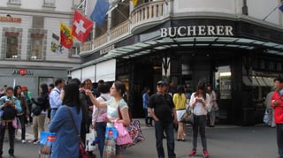 Eine Gruppe Touristen aus Asien steht auf dem Schwanenplatz.