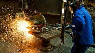 Arbeiter, der Gusseisen verarbeitet. Es sprühen Funken.