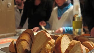 Brotkorb im Vordergrund, im Hintergrund Kind am Suppe schöpfen Brotkorb im Vordergrund, im Hintergrund Kind am Suppe schöpfen