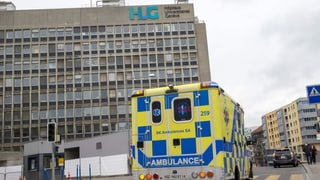 Eine Ambulanz fährt am Hauptgebäude des Universitätsspital Genf vorbei. Eine Ambulanz fährt am Hauptgebäude des Universitätsspital Genf vorbei.