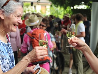 Zwei Frauen stossen mit einem Glas Wein auf das Erreichen des Ziels an.