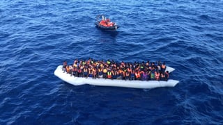 Ein Boot voller Flüchtlinge – daneben ein Rettungsboot 