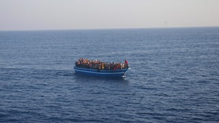 Flüchtlingsboot mit Menschen im Meer